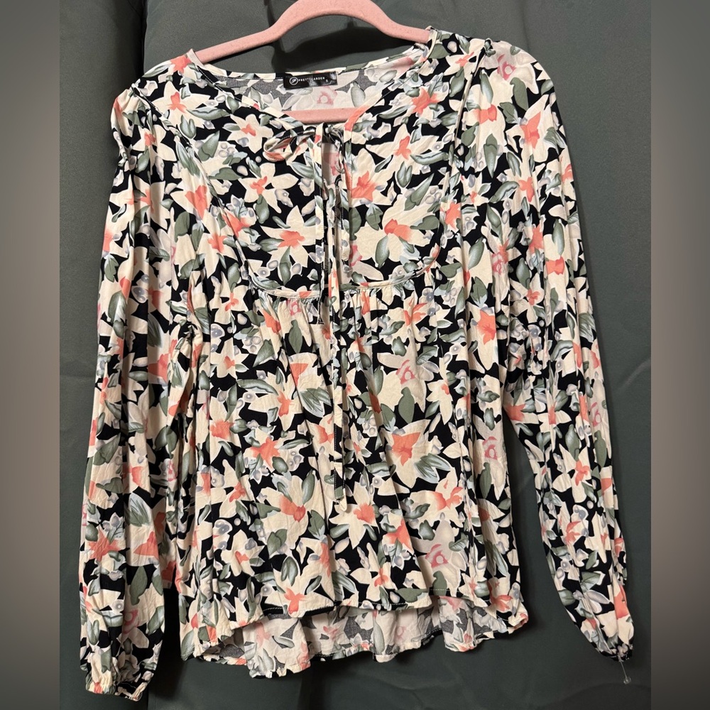 Adorable floral blouse with little bow tie detail on front. Size S